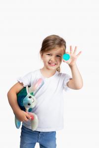 Girl holding a plush sea turtle with a token