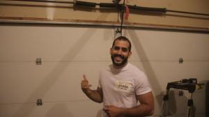 Jacob Walsh, owner of MYA Garage Door, inspecting a broken garage door spring in Seattle, WA