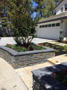 Landscaped front yard with stone walls and driveway done by South Canyon Construction