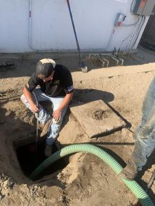 Rescue Hero Plumbing team watering a hole as part of septic system repair and preparation work in Bakersfield, California.