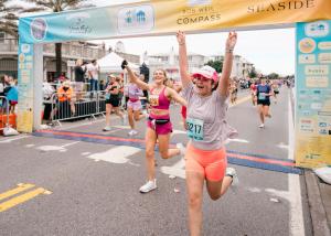Runners cross the finish line at the SEASIDE SCHOOL™ Half Marathon + 5K.