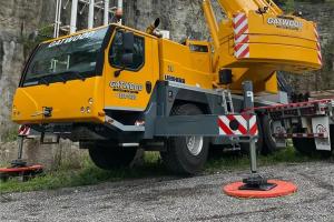 RhinoGuard™ composite outrigger pad in use under a mobile crane outrigger — heavy equipment safety solution for construction and utility operations.