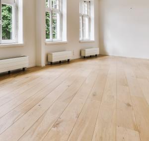 Hardwood floors in an empty room next to windows.