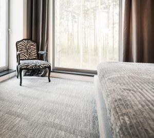 Chair on carpet next to a bed.