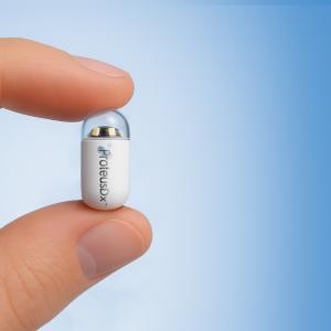 Close-up of the ProteusDx AI-powered capsule endoscopy device held between fingers, highlighting its small, patient-friendly design for non-invasive GI diagnostics