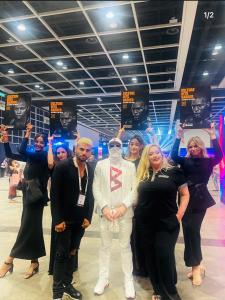 Group at Bitcoin Asia; Bitcoin Boxing team with ring ambassadors holding “Culture Hits Harder” posters after the global reveal.