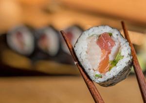 Chef japonés en restaurantes en Polanco sirviendo nigiris recién preparados en la barra de sushi.