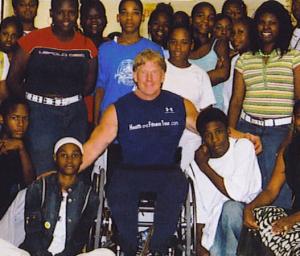 Man in a wheelchair next to a group of students.
