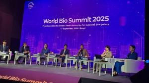 Wide shot of the World Bio Summit 2025 panel in Seoul (17 Sept 2025): Zen KOH sits center-right holding a microphone, with six fellow panellists on stage against a purple “World Bio Summit 2025” backdrop.