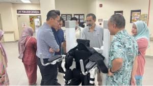 HSB multidisciplinary workshop: clinicians gathered around the UGO exoskeleton, rotating through setup, parameter tuning, and emergency-stop drills to standardise use.