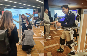 RoboCT booth at RehabWeek 2025 with a live exoskeleton demo: clinician guiding a participant through supported steps while engineers monitor control screens.