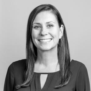 black and white headshot of a woman with shoulder length brown hair who is smiling