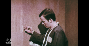 Image shows a POW tapping on the wall as a way to communicate with fellow prisoners.