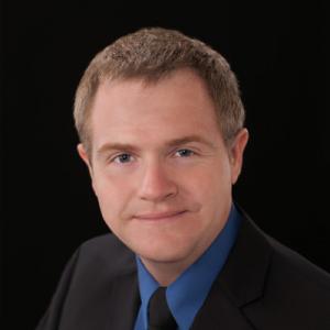 Professional style headshot of a man wearing a suit