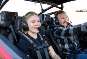 Two people in a UTV wearing their headsets for off road communication