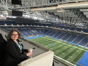 Tracey Birkenhauer sitting in the press area of Ford Field, home of the Detroit Lions