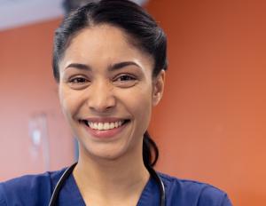 Nurse in a hospital room smiling.