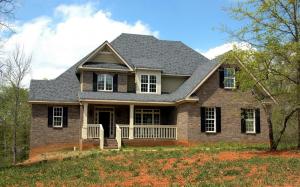 Two-story brick home with new gray shingle roof after storm damage inspection and repair