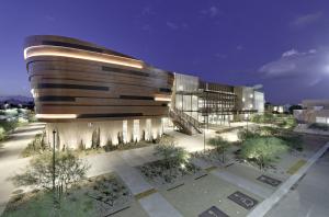 A photo of a modern multistory building in the Arizona desert at evening, showing bold architecture, clean accent lighting and southwestern landscaping.