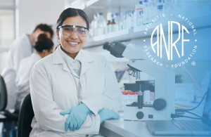 Researcher smiles at camera in lab.