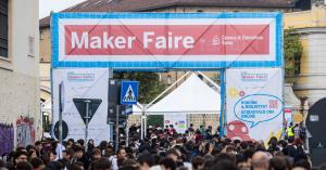 Entrance Gate Maker Faire Rome  banner and a large crowd of attendees at Gazometro Ostiense, Rome