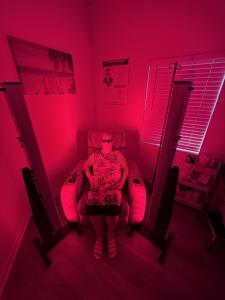 Person seated and wearing protective glasses during red light therapy treatment inside a private room at South Beach Wellness Clinic