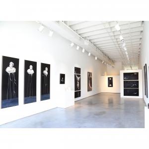Black and white surrealism paintings by Linda Cosgrove featuring torso and the four elements represented as four heads on stilt type stands