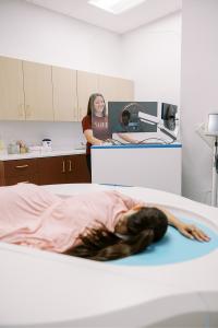 Patient receiving a pain-free mammogram at Shero Imaging in St. Louis using Koning Vera breast imaging technology with technologist at workstation.