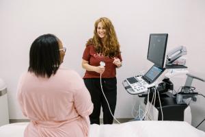 Technologist at Shero Imaging in St. Louis preparing patient for breast ultrasound exam using advanced imaging equipment for cancer detection.