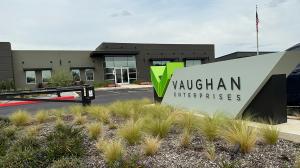 A picture of Vaughan Enterprises (Vaughan Automotive) in Boerne, TX with landscaping and a United States flag.