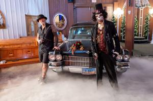 a vintage hearse is parked inside a wedding chapel with two men in costume for the Cursed Hearse wedding package at Viva Las Vegas Weddings