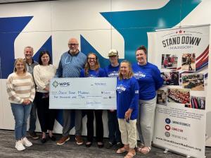 Representatives from WPS Charitable Foundation and Stand Down Madison hold a large ceremonial $5,000 check in support of local veterans.