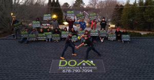 Dom Roofing & Restoration crew celebrating GAF Master Elite certification on a roof in Atlanta GA