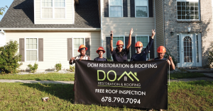 Dom Roofing & Restoration team holding a banner offering free roof inspections in Buford GA
