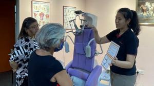 Product & clinical specialist Audrey Richard from Robotimize Group demonstrates the SuperTrac spinal traction system’s operating procedure to Ms. Sashira & Mdm. Sarkuna of Sentral Vista Physio & Rehab, pointing out controls and safety features during hands-on training.
