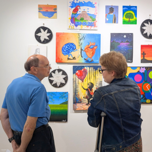 Members of the Ann Arbor community view artwork made by scholarship students at International Samaritan's headquarters.