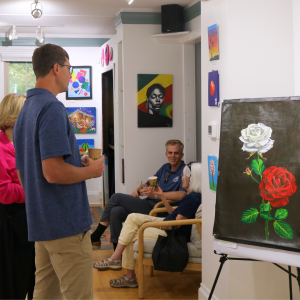 Members of the Ann Arbor community are looking at art that was made by scholarship students.