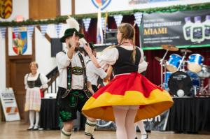 Man and woman in Bavarian attire performing a traditional folk dance at Oktoberfest Miami.