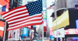American flag over Times Square, symbolizing U.S. opportunity and legacy for high-net-worth families considering EB-5 investment.