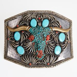 Massive 20th century Navajo silver metal belt buckle with a central longhorn design with turquoise and coral. Estimate: $600-$800.
