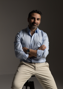Masoud Saman one of the best new york and american rhinoplasty and facelift surgeons with dual board certification in a white shirt smiling