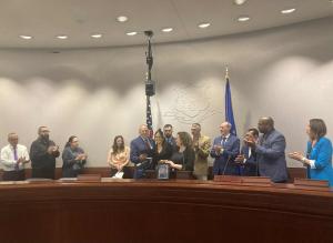 Edward Ramsdell, veteran and advocate, and Samantha Sirois Pawloski stand with State Representative Rebecca Martinez (D-Plainville) as she presents a proclamation declaring September 30, 2025, as Military Suicide Awareness and Remembrance Day at the Legis