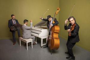 four lively Argentine Tango musicians playing in a colorful gallery