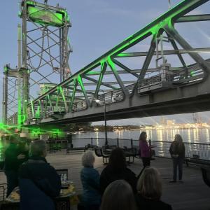 Side view of Portsmouth's Memorial Bridge lit up in green