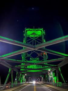 Front view of Portsmouth's Memorial Bridge lit in green.
