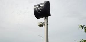 Automated Traffic Safety Camera System shows a black box on a pole with the words NovoaGlobal