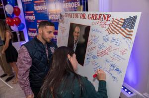 First responders and families sign a thank-you board for Dr. Kevin Greene during the Confidia Cares: Honor Our Heroes Celebration.