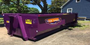 Purple 20 yard roll-off dumpster from Trash Daddy Dumpsters placed in a driveway