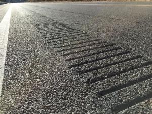image shows grooves in asphalt that play a tune when driven over