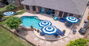 AI photo to video software turns a drone photo of a modern backyard with pool and patio into a cinematic aerial video scene.